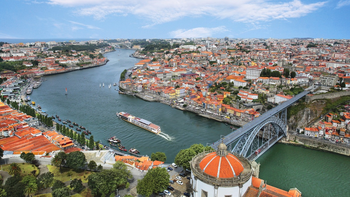 River ship sailing on the Douro in front of Porto and the Dom Luís I Bridge.