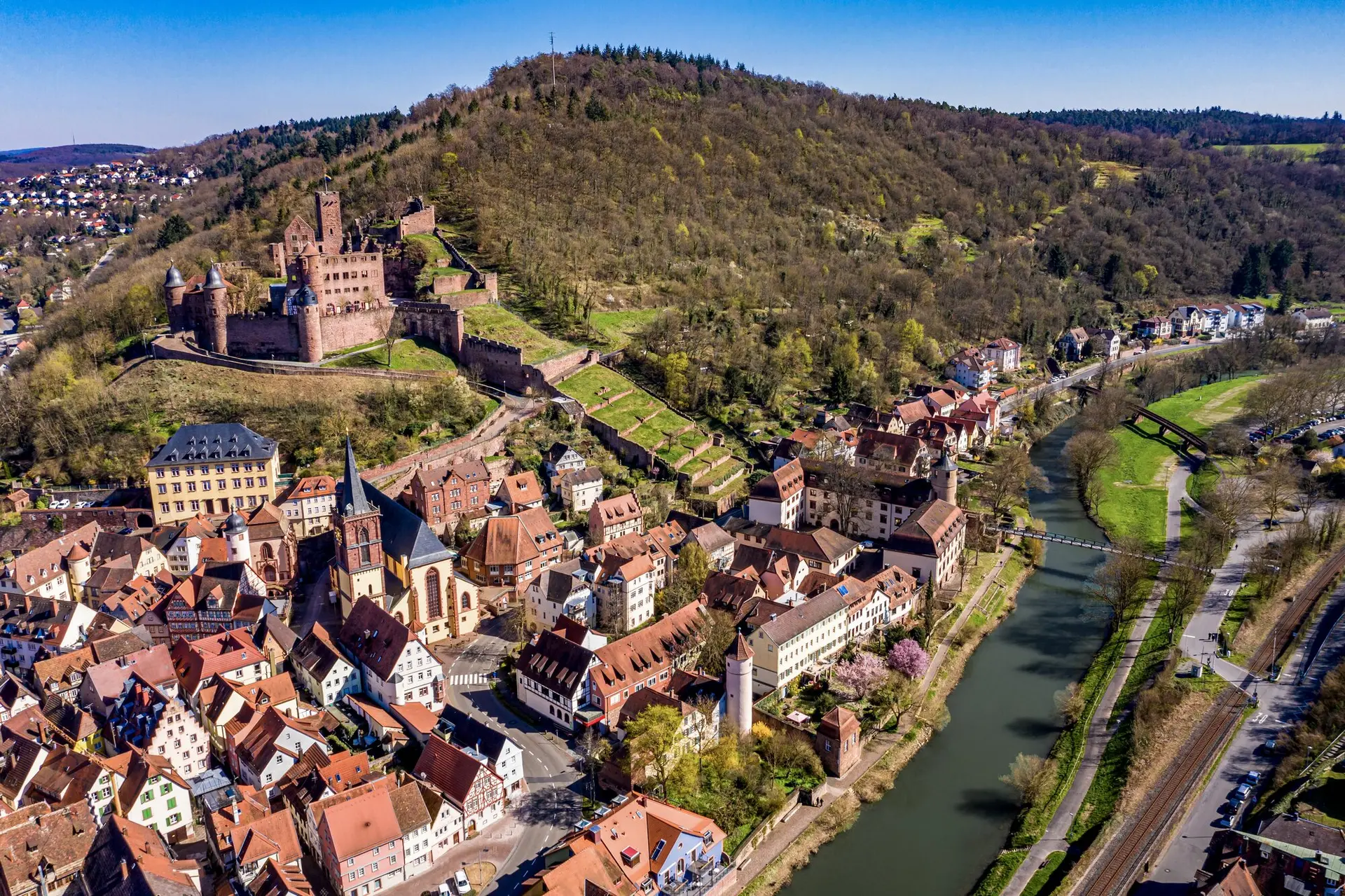 Historic town beside a river, with a castle on the hill, along a European river cruise route.