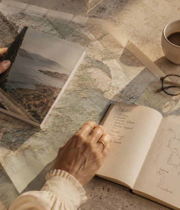 Mapas, libreta y notas durante el diseño de una ruta de viaje personalizada.