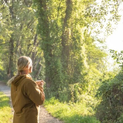 She enjoys coffee, and looks out through lush forest